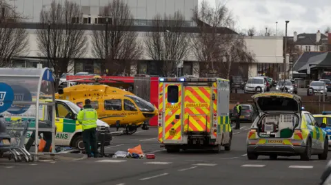 Alan Simpson An air ambulance, ambulance and emergency service presence in a Tesco car park.
