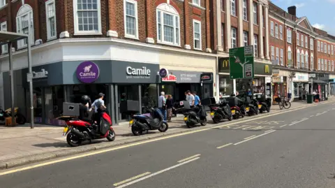 BBC Epsom High Street, motorcycles on the pavement, McDonalds, Papa Johns