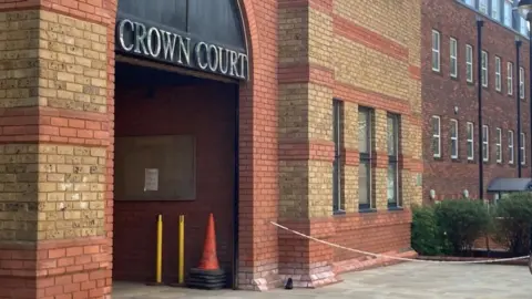 Brian Farmer/BBC St Albans Crown Court: A red and yellow brick building. The words CROWN COURT are written in silver capitals above the entrance.