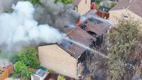 Two residential properties damaged by fire. Firefighters are battling the blaze.