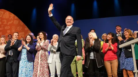 PA Ed Davey with Lib Dem MPs on conference stage