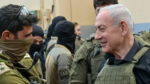 GPO Israeli Prime Minister Benjamin Netanyahu (R) speaks to Israeli soldiers in southern Lebanon