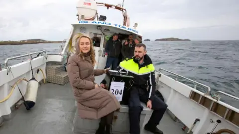 Getty Garda officer and election official pictured at sea on a boat holding ballot box