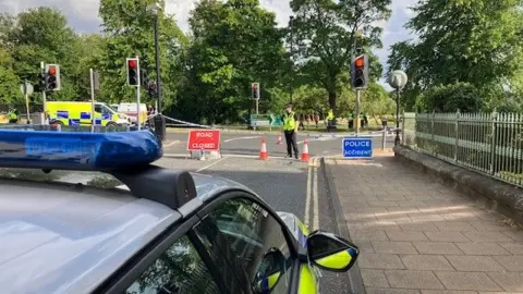 Phil Bodmer/BBC Police at the scene of the road closure on York Place.