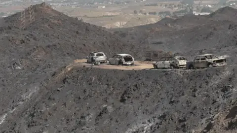 Reuters Four cars surrounded by the ashes in the aftermath of a wildfire in Spain.