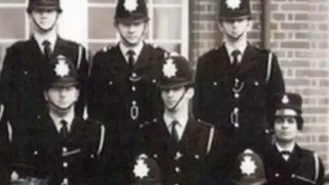Metropolitan Police A black and white photograph of PC Karpal Kaur Sandhu in her police uniform with other, male police officers