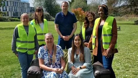 NHFT A group of people by a sofa 