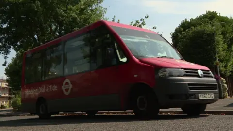 BBC A red Dial a ride minibus driving on the road