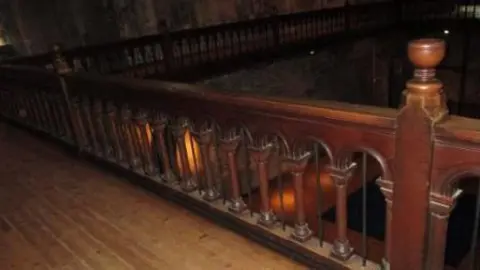 The Reclaim and Salvage Company Gothic arched wooden balustrades with goblet finials, turned supports with metal rod inserts pictured in the castle keep.