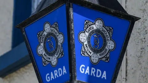 A lamp outside a Garda station featuring the logo of An Garda Siochana - which is white on a blue background.