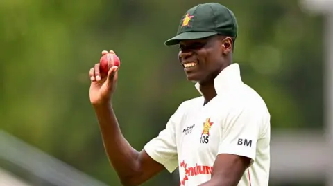 Zimbabwe's Blessing Muzarabani holds up the ball