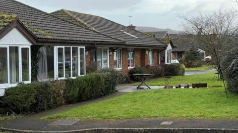 External shots of Furlong House, a set of bungalows with small lawns out the front.