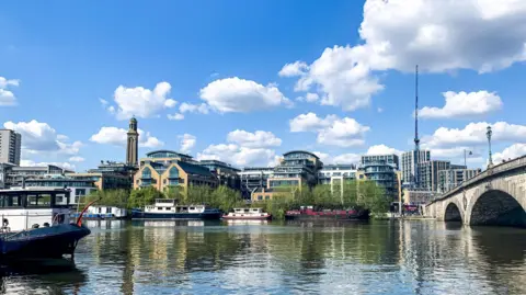 Getty Images The river Thames at Brentford pictured from Kew. Kew Bridge can be seen to the right, and many modern buildings can be seen on the riverside. A water tower is visible in the background, which is now a museum.