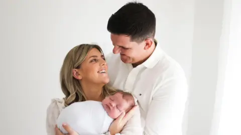 Victoria and Ryan Thomas pictures with their son, Teddie, shortly after he was born with his Mum cradling him in her arms.