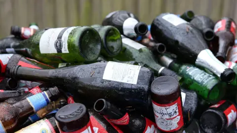 A huge pile of empty and upturned wine and beer bottles ready for recycling.