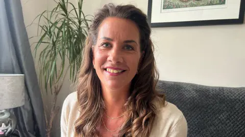 A former professional swimmer, with long brown hair, smiling at the camera