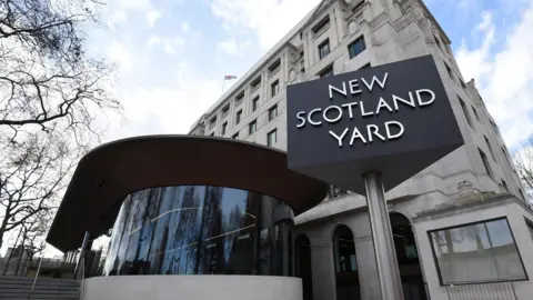 PA Media An exterior shot of New Scotland Yard in London and its recognisable rotating triangular sign