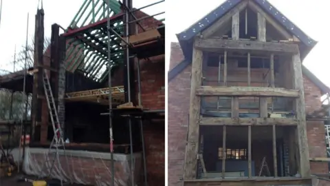 Celia Wilson Two side‑by‑side photos showing a brick building under major construction. Left photo: A partially built structure stands surrounded by scaffolding. The walls are made of red brick, and the wooden roof frame is exposed, with green timbers forming the skeleton of a pitched roof. Several beams and planks are supported by metal poles, and ladders lean against the structure. The lower part of the building is open, with no windows or doors installed yet. Building materials and tools are scattered around the site. Right photo: This image shows the front of the same building from a straight‑on view. The full height of the structure is visible—three storeys tall—with a steep, triangular roof. The façade features large, thick, weathered wooden beams forming the framework for what will likely be large windows. The interior is still empty and unfinished, with floors and ceilings visible through the open spaces. A ladder stands inside the ground floor, and more scaffolding is set up around the sides.