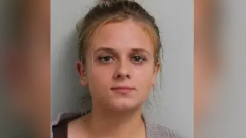 Custody image of Roksana Lecka. She is looking directly at the camera wearing a woollen type cardigan.