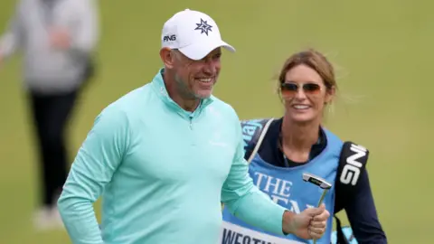 Golfer Lee Westwood and caddie Helen Storey on a golf course