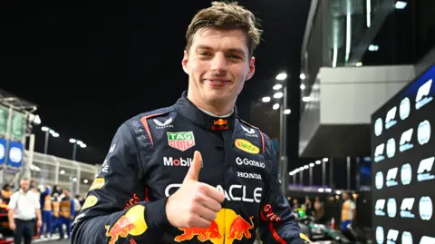 Max Verstappen, in Red Bull racing outfit, gives a thumbs-up salute