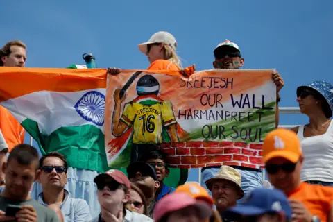 Reuters Paris 2024 Olympics - Hockey - Men's Bronze Medal Match - India vs Spain - Yves-du-Manoir Stadium, Colombes, France - August 08, 2024. An Indian fan holds up a banner supporting his team. 