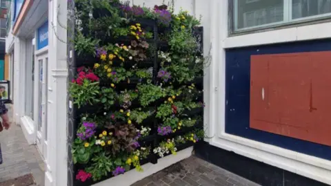 North East Lincolnshire Council A living wall of plants up the side of a building on a shopping street in Grimbsy.