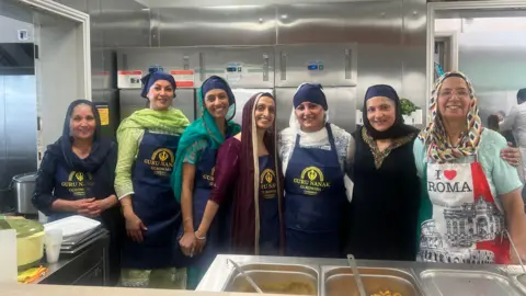 BBC/Julia Moore Women from the Guru Nanak Gurdwara Camberley cooking and serving food to all attendees