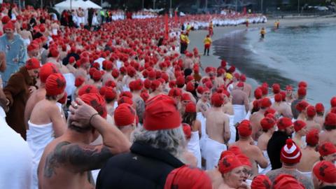Swimmers on the beach in Hobart for the naked winter solstice swim