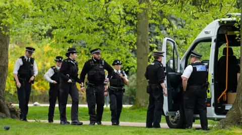 Several police officers getting out of a van in Kensington Gardens