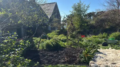 Lois Roberts A garden seen with a patch of soil for growing vegetables.