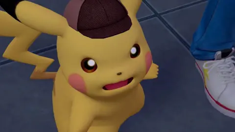 The Pokémon Company Pikachu - the iconic yellow mascot of the Pokémon series - is seen in a screenshot wearing a deerstalker hat like the type worn by Sherlock Holmes. He has a shocked expression on his face, as if he has just learned some important information.