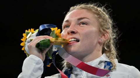 Lauren Price bites her gold medal at the Olympics