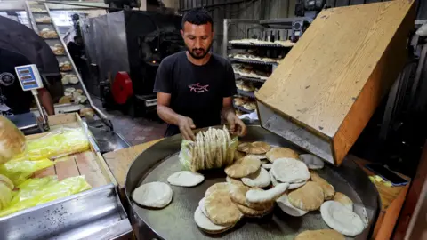 Reuters A bakery in Deir al-Balah, central Gaza, produces pita breads after receiving flour from a UN aid shipment (22 May 2025)