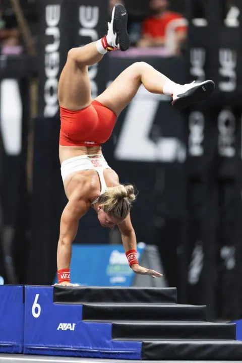 CROSSFIT GAMES Cringle on balancing on one hand in a handstand.