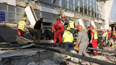 Reuters Rescue workers remove debris after a roof collapsed at the entrance to a railway station in Novi Sad, Serbia, November 1, 2024.