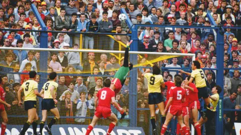 Getty Images Liverpool fans watch the goalmouth action on the terraces from behind the safety fences, from a League Division One match between Oxford United and Liverpool at the Manor Ground on September 14, 1985 in Oxford, England.