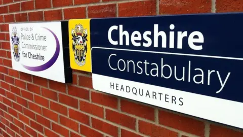 BBC A sign for Cheshire Constabulary's headquarter set against a brick background. 