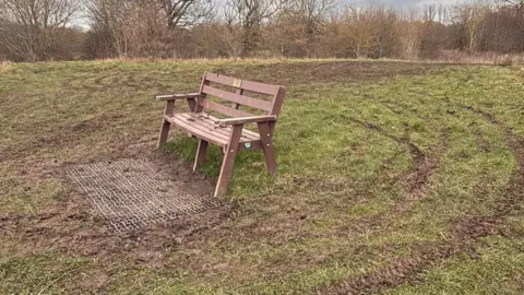 Katherine Errington A brown bench has been surrounded with churned up grass tracks created by off-road bikes.