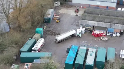 A bird's eye view of tankers and lorries in a depot.