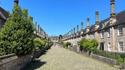 BBC A cobbled street of period terraced houses with chimneys