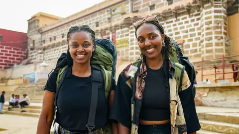 Sisters Elizabeth and Letitia, from West Sussex, pictured during this year's Race Across the World. Both are wearing black T-shirts and carrying green rucksacks. 