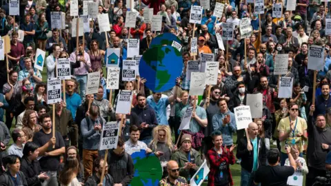 Getty Images Amazon workers gather for a rally during a walkout event at the company's headquarters on May 31, 2023 in Seattle, Washington. The protest action was organized to call attention to return to office requirements, in addition to recent layoffs and climate change issues. 