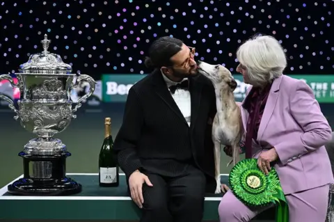 Getty Images Miuccia, a whippet, poses with owner Giovanni Liguori, from Italy, and judge Patsy Hollings 