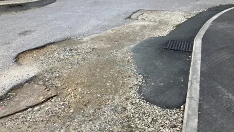 A road covered in rubble and holes