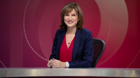 Fiona Bruce sitting at a desk for BBC Question Time