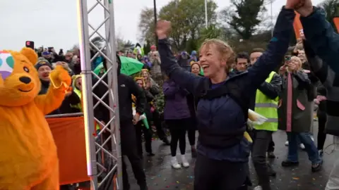 Sara Cox celebrates crossing finishing line