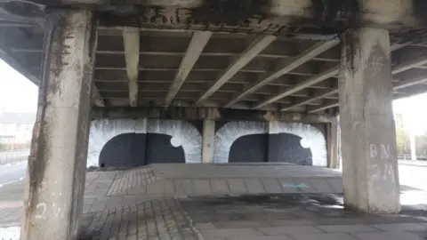 Psa A large mural showing two eyes, underneath a motorway
