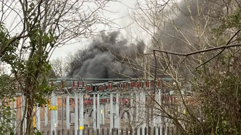Grey smoke seen behind an electrical substation