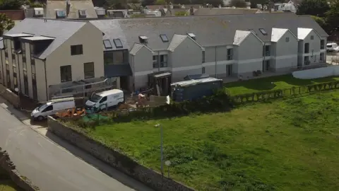 A two-storey block with new two-storey units and what appears to be construction work going on.